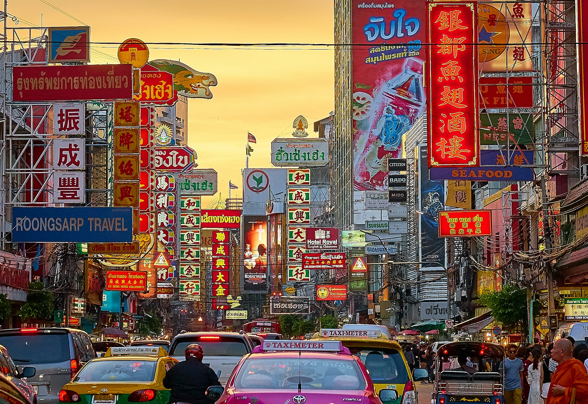 Bangkok Chinatown street with colourful Thai and Chinese signs, busy traffic and city life Bangkok Chinatown street with colourful Thai and Chinese signs, busy traffic and city life